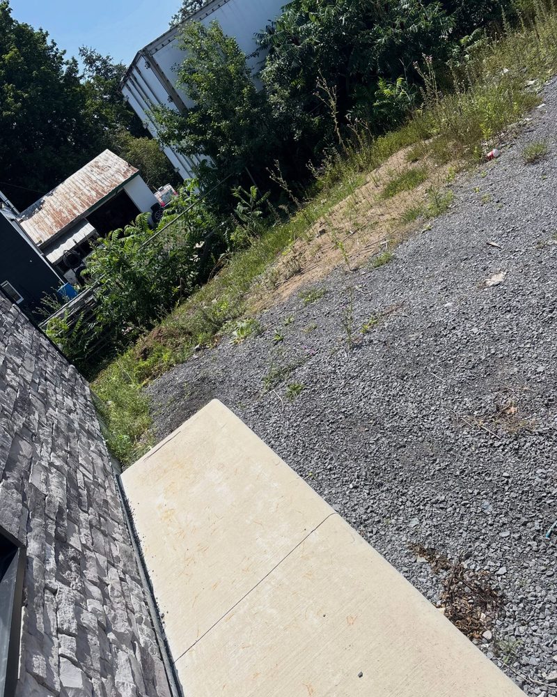 The same Kingston side yard, cleared down to the bare gravel and concrete pad