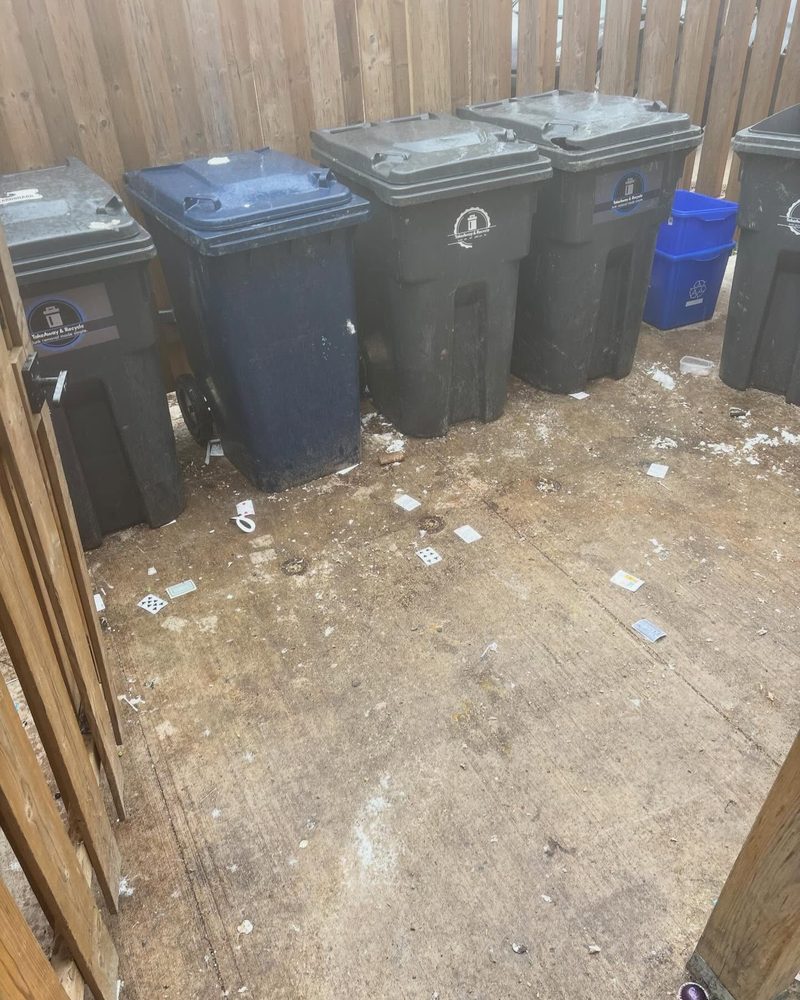 The same bin enclosure with the bins lined up and the ground swept clear
