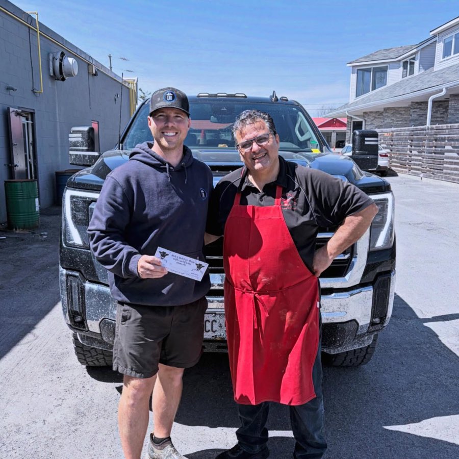 Brock and a local butcher shop owner in his red apron in front of the truck