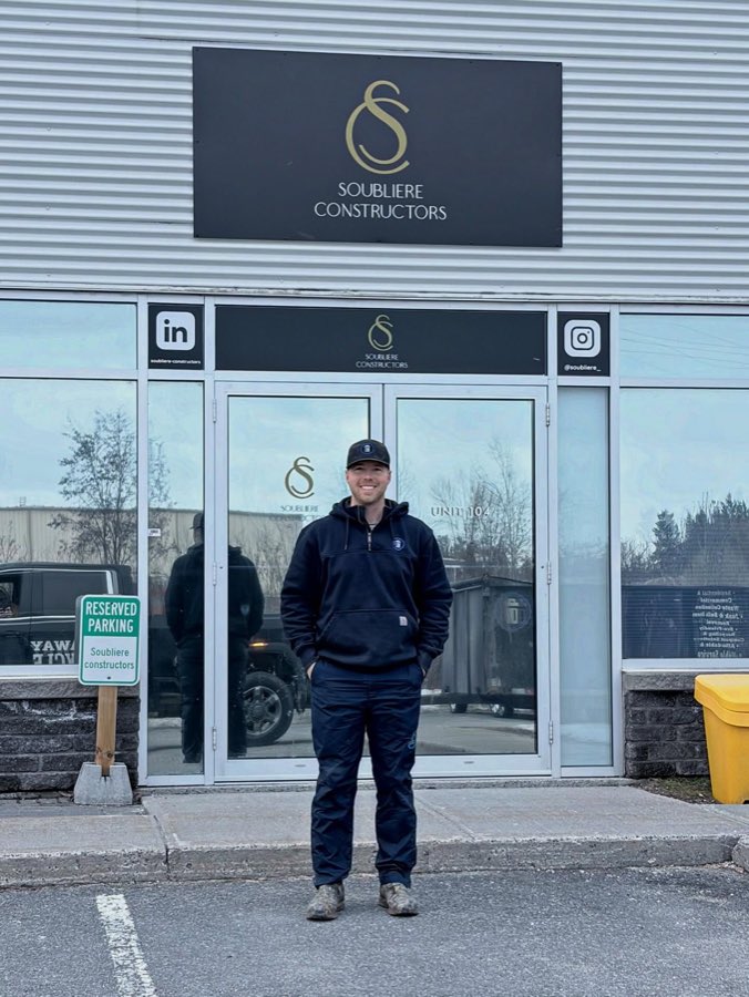 Brock outside Soubliere Constructors, with the company trailer parked behind him