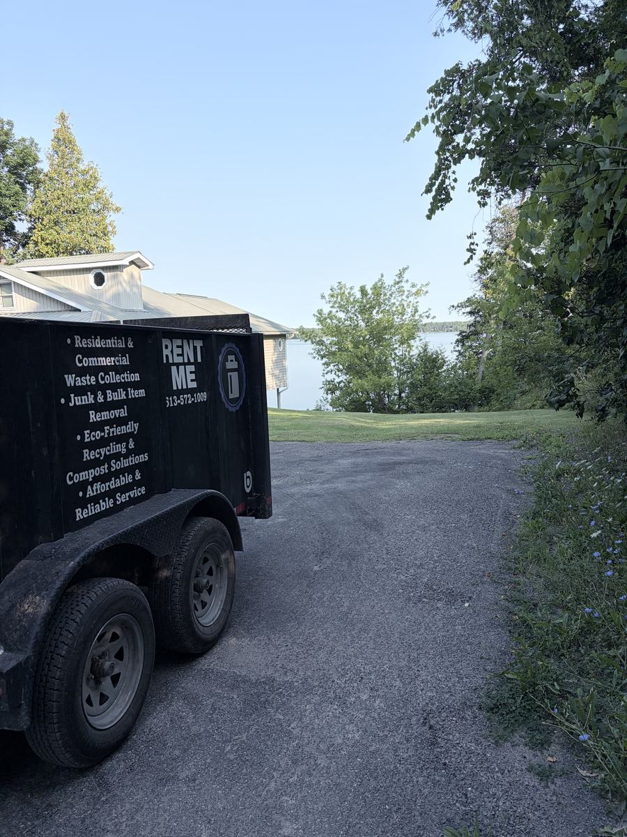 The Rent Me dump trailer parked on a gravel lane at a waterfront property outside Kingston